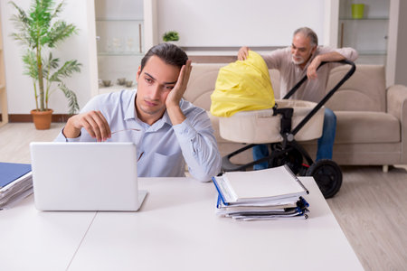 Retired grandfather looking after newborn at homeの写真素材