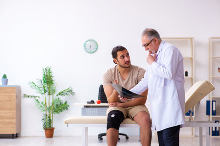 Experienced doctor radiologist examining young male patientの写真素材