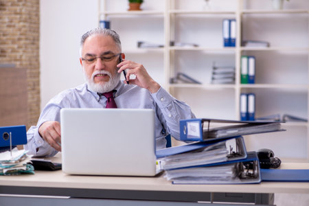 Old male accountant in budget planning concept in the officeの写真素材