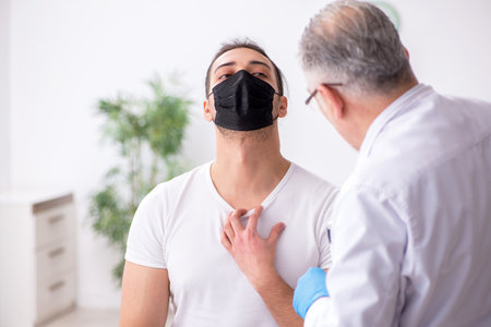 Young man visiting experienced doctor dermatologist