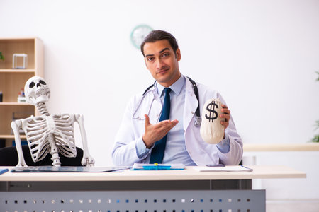 Young male doctor and skeleton patient in expensive medicine conの写真素材
