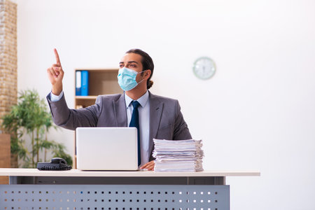 Young male employee wearing mask during pandemicの写真素材