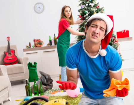 Young family cleaning apartment after christmas partyの写真素材