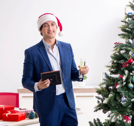 Young employee celebrating christmas at workplaceの写真素材
