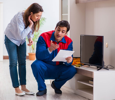 Repairman repairing tv at homeの写真素材