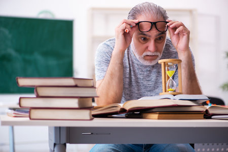 Old male student in time management conceptの写真素材