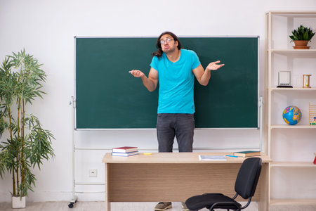 Young male student in front of green boardの写真素材