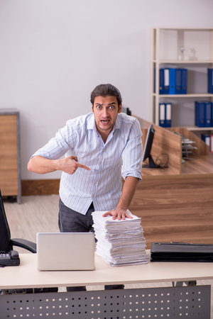Young male employee unhappy with excessive workの写真素材