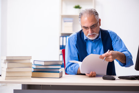 Old male author writing booksの写真素材