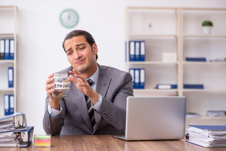 Young male employee in pension concept at workplaceの写真素材