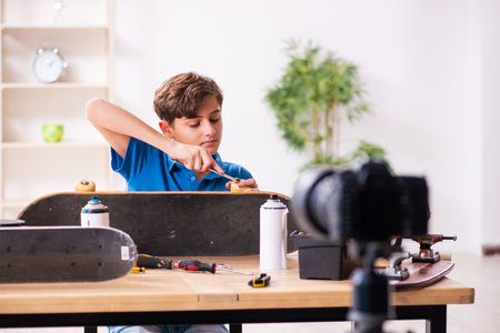 Boy repairing skateboard and recording video for his blogの写真素材