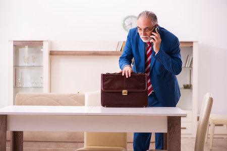 Old male boss employee coming home from workの写真素材