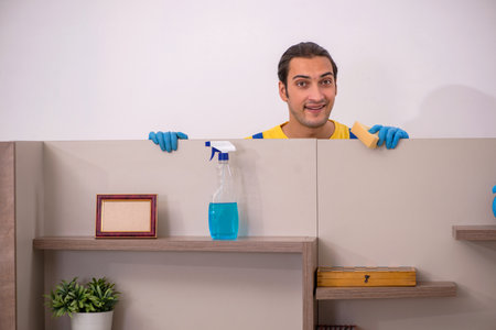 Young male contractor cleaning the house