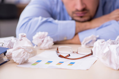 Sick male employee suffering at workplaceの写真素材