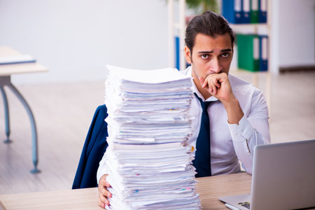 Young male employee unhappy with excessive workの写真素材