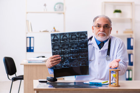 Old male doctor radiologist in time management concept