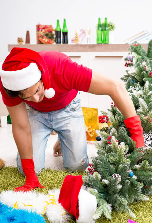 Man cleaning his apartment after christmas partyの写真素材