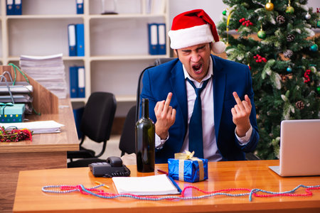 Young male employee celebrating Christmas at workplaceの写真素材
