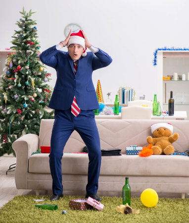 Young handsome employee celebrating Christmas at workplaceの写真素材