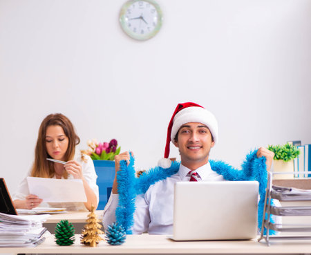 Man and woman working at the office on Cristmass eveの写真素材