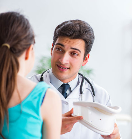 Doctor showing type of injury on skeleton to patientの写真素材