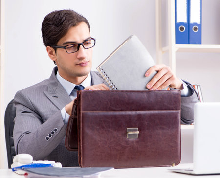Young handsome businessman employee working in office at deskの写真素材