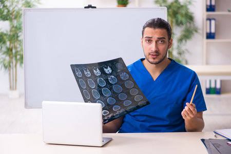 Young male doctor teacher radiologist in front of whiteboard