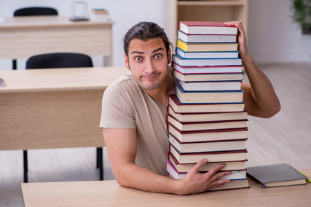 Young male student preparing for exams at libraryの写真素材