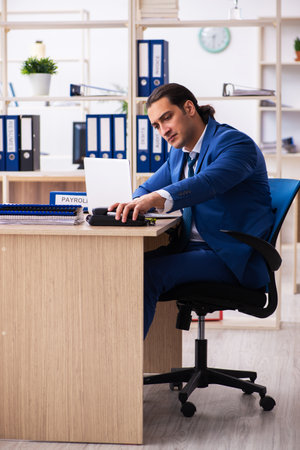 Young handsome employee sitting in the officeの写真素材
