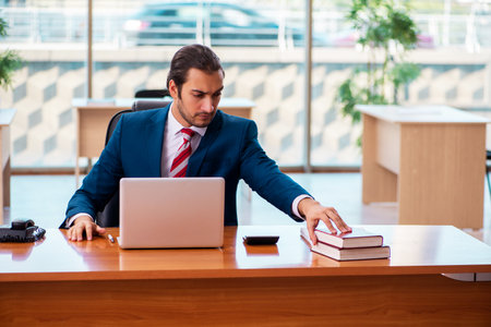 Young handsome employee working in the officeの写真素材
