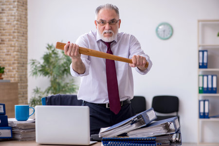 Aged male employee unhappy with excessive workの写真素材