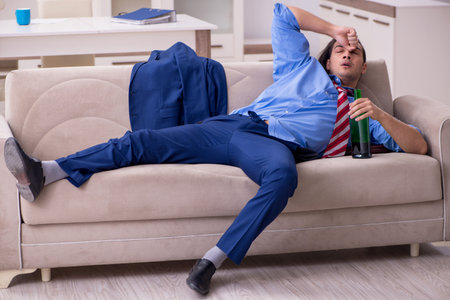 Young male employee being fired from his work at homeの写真素材