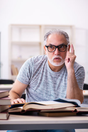 Old male student preparing for exams in the classroomの写真素材