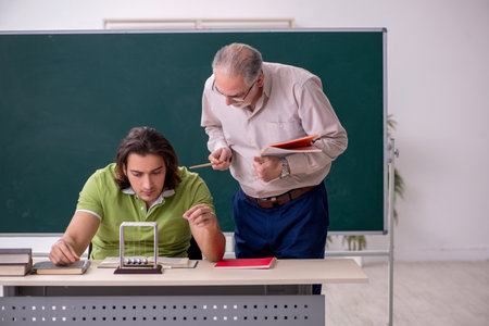 Old professor physicist and young student in the classroomの写真素材