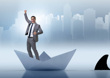 Excited businessman riding paper ship boatの写真素材