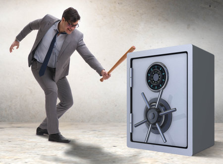 Angry man with baseball bat hitting money safeの写真素材