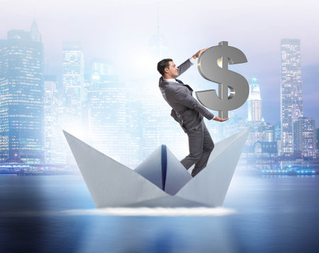 Businessman holding dollar riding paper ship boatの写真素材