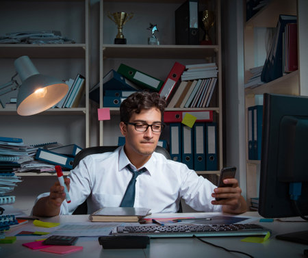Man businessman working late hours in the officeの写真素材