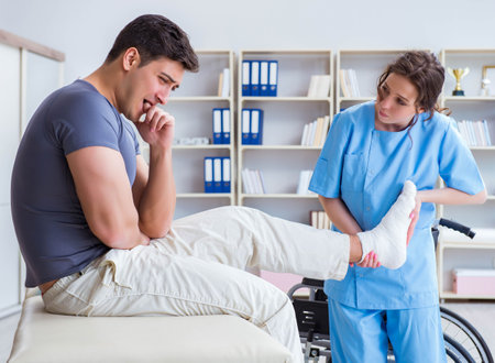 Doctor and patient during check-up for injury in hospitalの写真素材