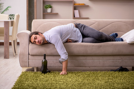 Young drunk man suffering at homeの写真素材