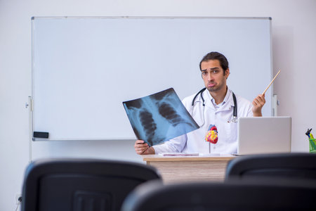 Young male doctor radiologist giving seminar in the classroom