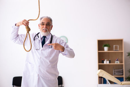 Old male doctor committing suicide at workplaceの写真素材