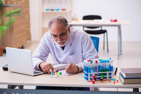 Old male chemist taking notesの写真素材