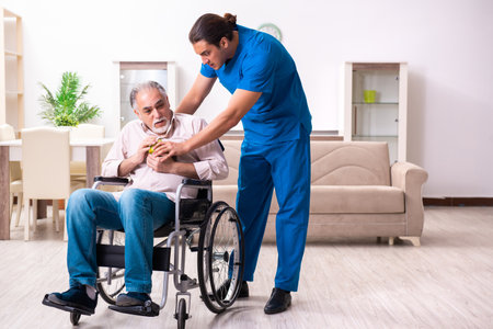 Old man in wheel-chair and young bad caregiver indoorsの写真素材
