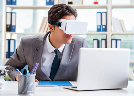 Businessman with VR virtual reality glasses in officeの写真素材