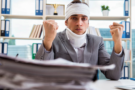 Injured businessman working in the officeの写真素材