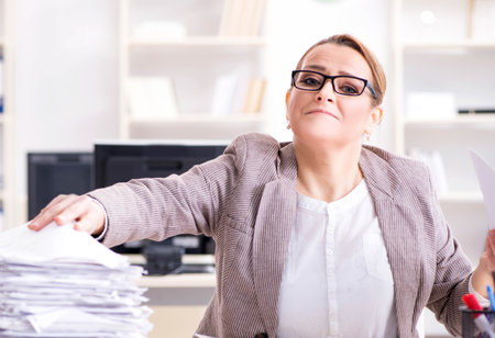 Businesswoman very busy with ongoing paperworkの写真素材