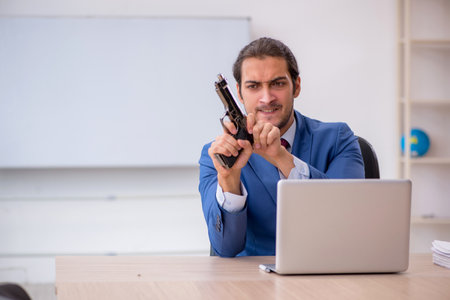 Young male employee sitting in the office in front of whiteboardの写真素材