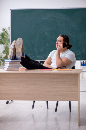Young male teacher student sitting in the classroomの写真素材