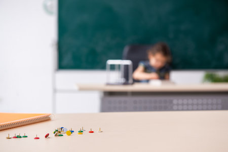 Small girl and thumbtacks in the classroomの写真素材
